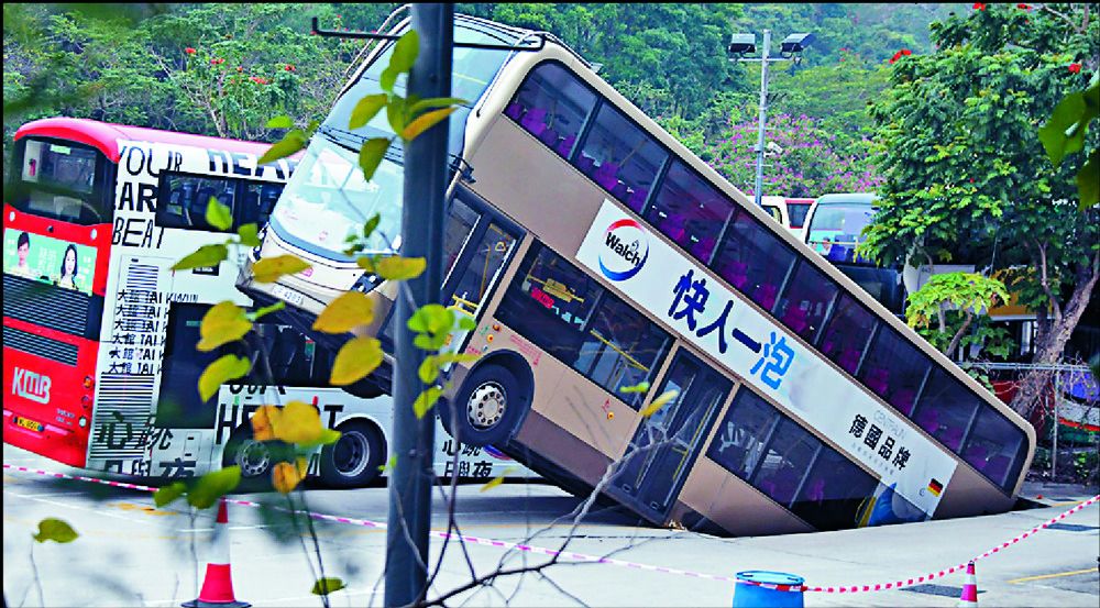 Double-decker falls into hole